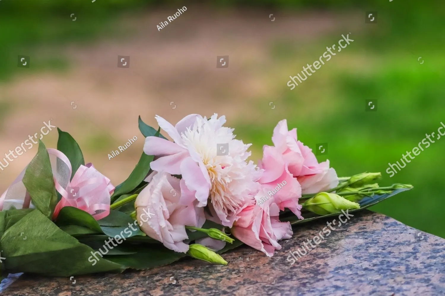 Pink peonies laid on a granite stone